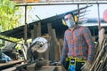 A carpenter is working in a woodworking office.caucasion white male carpenter using electric circular saw cut wood Royalty Free Stock Photo