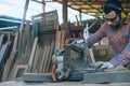 A carpenter is working in a woodworking office.caucasion white male carpenter using electric circular saw cut wood Royalty Free Stock Photo