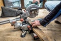 Carpenter works with a circular saw miter saw in a workshop