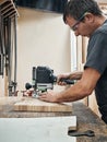 A carpenter works with a hand-held grinding machine Royalty Free Stock Photo