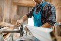 Carpenter works on plane machine, woodworking