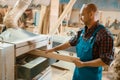 Carpenter works on plane machine, woodworking