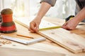 Carpenter works with wood in the workshop. A woman works in a carpentry workshop