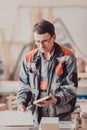 A carpenter works on woodworking the machine tool. Carpenter working on woodworking machines in carpentry shop. Royalty Free Stock Photo