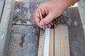The carpenter& x27;s hand measures the length. Measuring a wooden board with a tape measure. Royalty Free Stock Photo