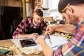 Carpenters with blueprint and dividers at workshop