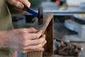 carpenters are preparing to hammer a nail into wooden product, close up