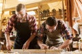 Carpenters with ruler and wood plank at workshop