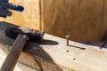 Carpenters uses a hammer to driving nail, Craftsmen and builder equipment. A man hammers an iron nail into a wooden beam