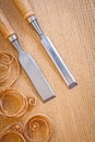 Carpentery chisels on wooden board with wooden shavings