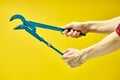 Carpentry Adjustable wrench isolated on yellow background in cropped male hands Royalty Free Stock Photo