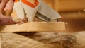 Male woodworker working in garage. Man professional carpenter working with materials in workshop sawing wood using Royalty Free Stock Photo