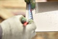 Carpentry, mans hand using tape measure to measure wood plank and marking it with pencil Royalty Free Stock Photo