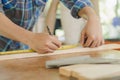 Carpentry professional, hand of asian young man, male carpenter use tape measure, tool on board wood in small shop. Woodwork,