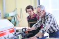Carpentry professor teaching young woman apprentice Royalty Free Stock Photo