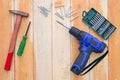 Carpentry tools of cordless drills, screw driver, screws, hammer and accessories on wood table