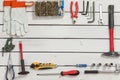 Carpentry tools lie evenly arranged on white wooden boards.