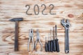 Carpentry tools on a light wood table with 2022 lined with screw nuts. The concept of New Year and Christmas in the construction Royalty Free Stock Photo