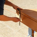 Carpenter pointing out the cut of a beech wood step with the metal carpentry square.