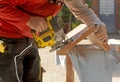 Carpenter cutting with a jig saw the beech wood stair step of a staircase