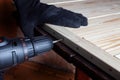 Carpentry work. The self-tapping screw is screwed into a wooden beam. Furniture assembly Royalty Free Stock Photo