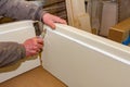 Carpenter cuts rubber with scalpel, make it easier to assembling wooden board parts of the door