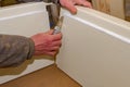 Carpenter cuts rubber with scalpel, make it easier to assembling wooden board parts of the door