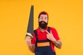 Carpentry workshop concept. Professional tools. Builder worker carpenter handyman hold saw yellow background. Man hold