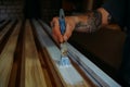 Painting wooden planks white, work in a carpentry workshop, a brush in a man's hand Royalty Free Stock Photo