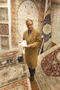 Carpet seller offering colorful oriental carpets at his store