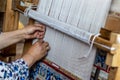 Carpet weaving close up. Senior woman`s hand weaves traditional manual silk carpet loom Royalty Free Stock Photo