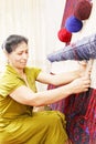 Carpet weaving woman sideview closeup