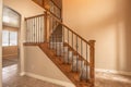 Carpeted stairs with wood handrail and metal railing inside an empty new home