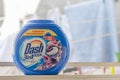 Savings pack for Dash washing machine capsules, produced by the multinational Procter and Gamble on a windows with cloths to dry Royalty Free Stock Photo