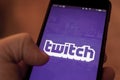 Man run Twitch application on a smartphone. Twitch is a live streaming platform owned by Amazon