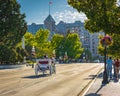 Carriage Ride In Victoria BC Canada at sunset. A horse drawn carriage with tourists passes the historical buildings