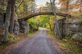 Carriage road with bridge surrounded by bright fall foliage on a partly cloudy afternoon Royalty Free Stock Photo