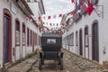 A carriage in a street adorned with flags for the Divine Holy Spirit Festivity in Paraty, Brazil. Royalty Free Stock Photo