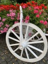 Carriage with wooden wheels as decoration for flowers. Traditional rural retro van, decor. Trolley with bright flowers for garden Royalty Free Stock Photo