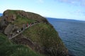 Tourists walking on Carrick-a-Rede Rope Bridge - Island in blue ocean - Northern Ireland tourism