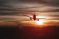 Carrier cargo airplane with landing gear makes an emergency landing over city at night in dramatic sunset sky. Danger of crash.