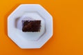Carrot cake with chocolate topping isolated on orange background