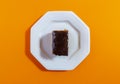 Carrot cake with chocolate topping isolated on orange background