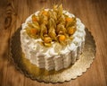 Carrot cake decorated with fresh physalis berries, wooden table
