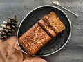 Carrot cake loaf made with oats and almonds, sliced on a black dish, top view. vegan, eggless cake. Healthy, diet, nutrition