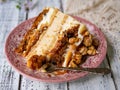 Carrot cake with salted caramel and cheesecake inside, decorated with popcorn and caramel. A slice of cake, retro style, vintage. Royalty Free Stock Photo