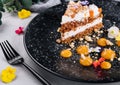 Carrot cake with walnuts on black plate Royalty Free Stock Photo