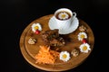 Carrot cakes in a section with walnuts and spices, next to a white porcelain Cup of tea, around walnuts, daisies with ladybirds Royalty Free Stock Photo