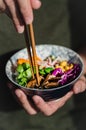 Vietnamese salad with mushroom, carrot, red cabbage an rice noodle hold by male hand with chopsticks. Royalty Free Stock Photo