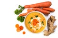 Carrot cream soup with ingedients, ginger root, raw carots and p Royalty Free Stock Photo